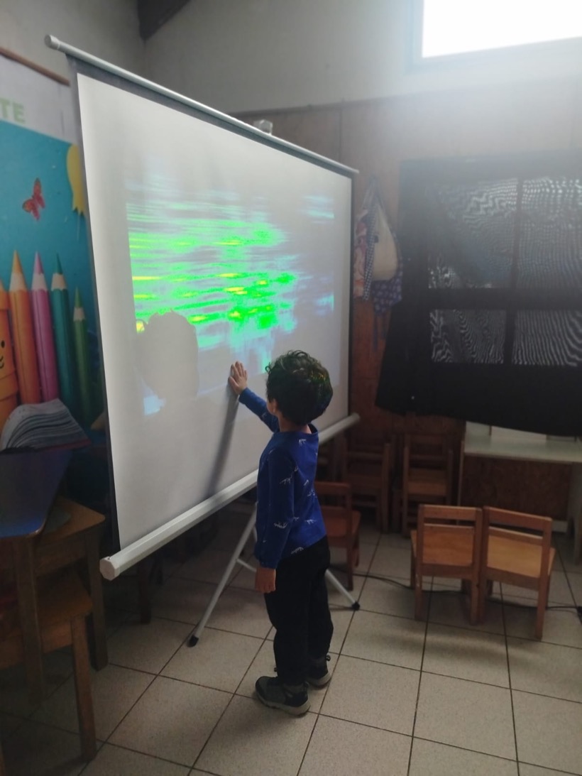 Niño explorando un espectrograma proyectado en la sala